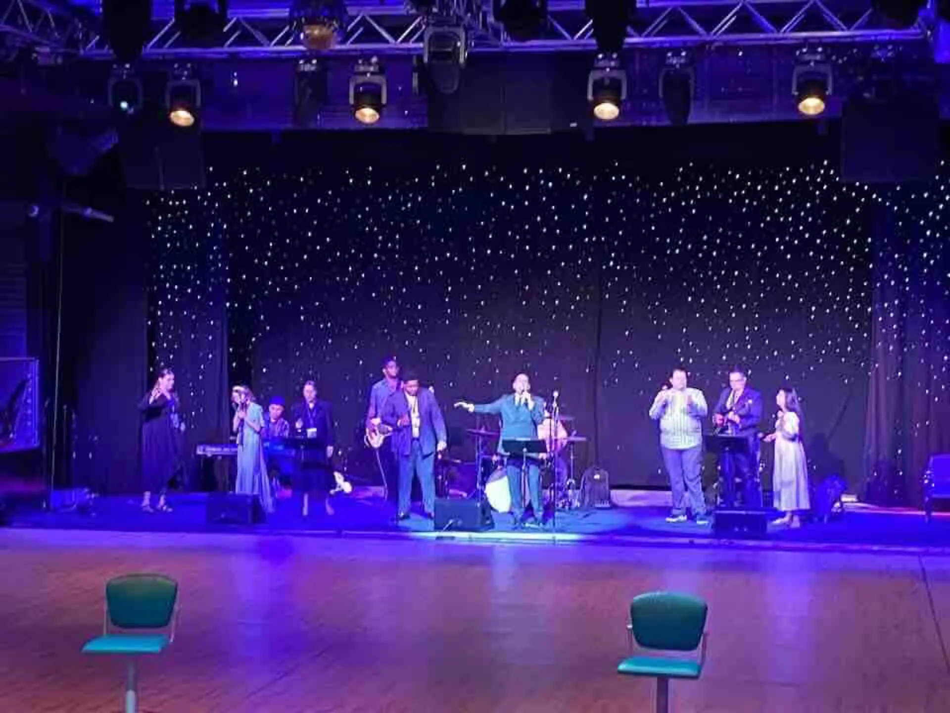 Singers on stage under blue lights